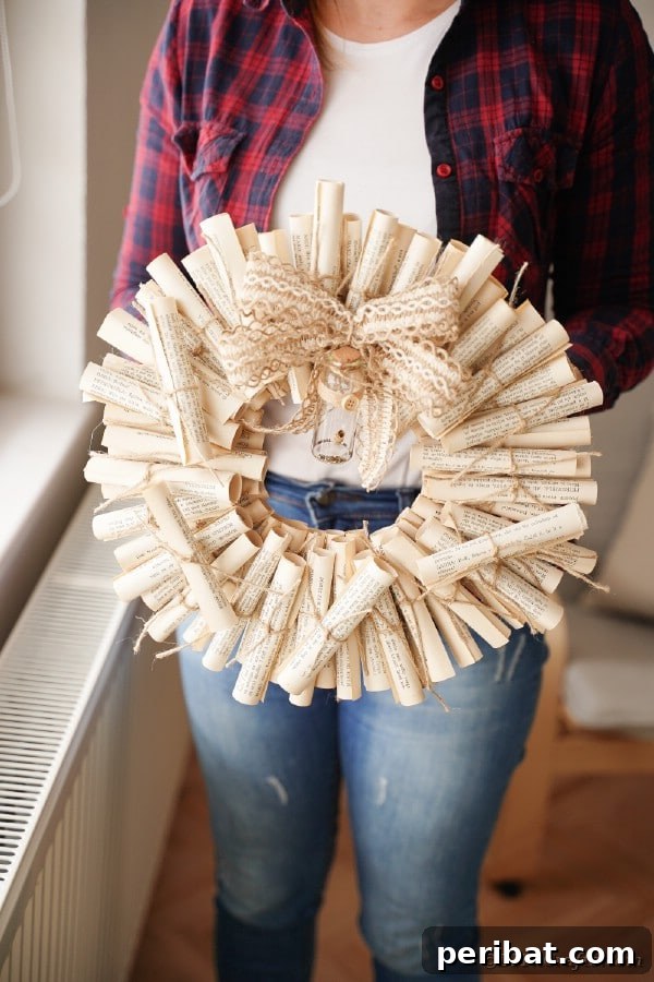 Unique upcycled book page scroll wreath, held by a woman