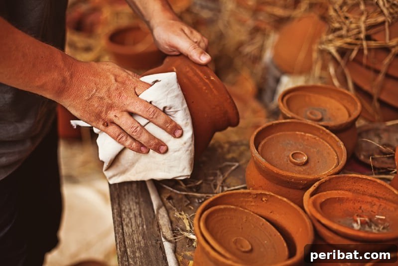 Gardener cleaning terracotta clay pots with a brush and bucket of vinegar solution.
