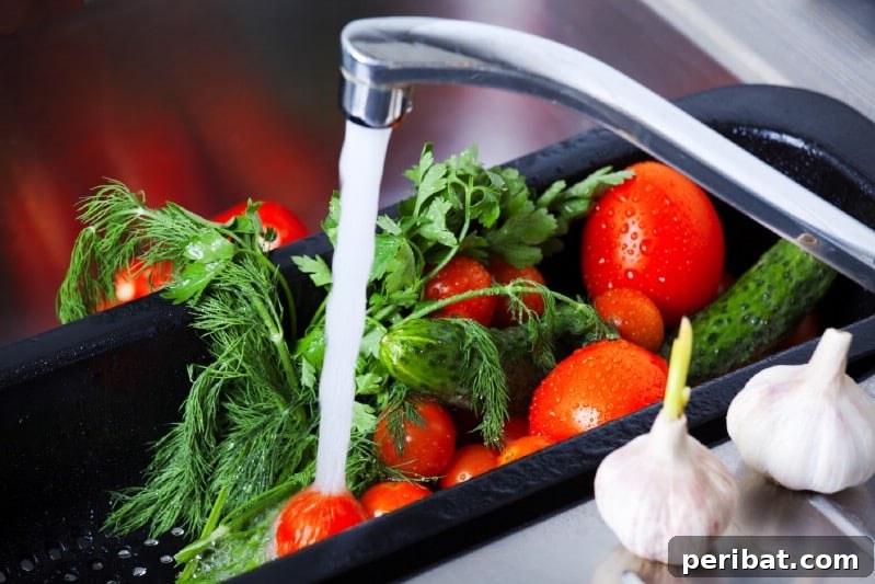 A person cleaning freshly harvested vegetables in a sink with a vinegar and water solution.