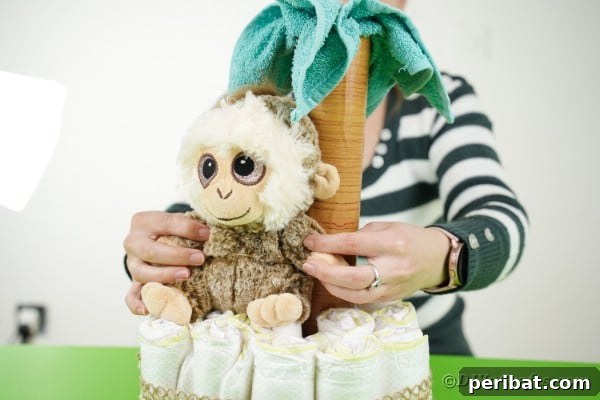Sweet Safari Palm Diaper Cake 18 Adding monkey to diaper cake