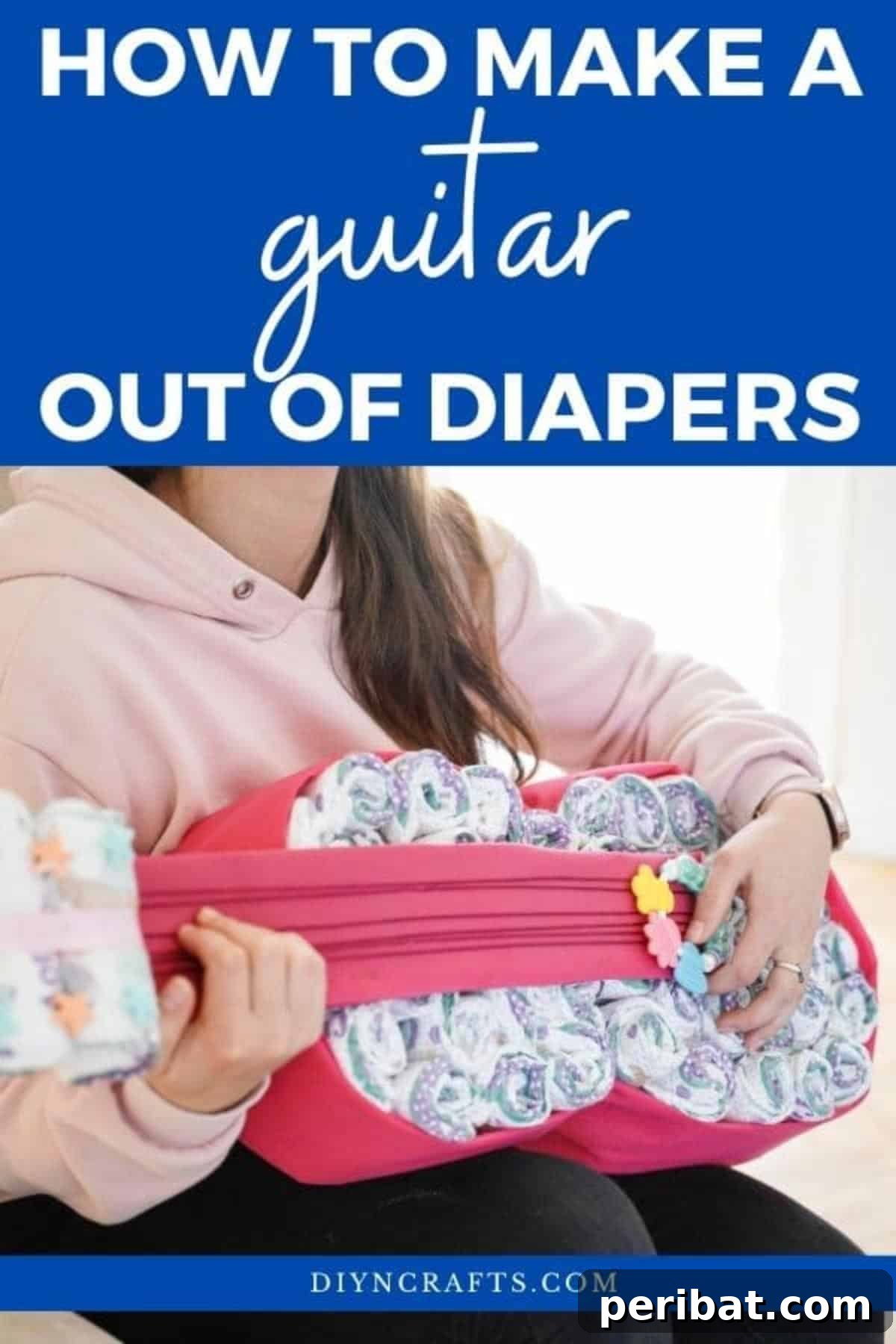 Woman holding a finished guitar diaper cake, smiling warmly