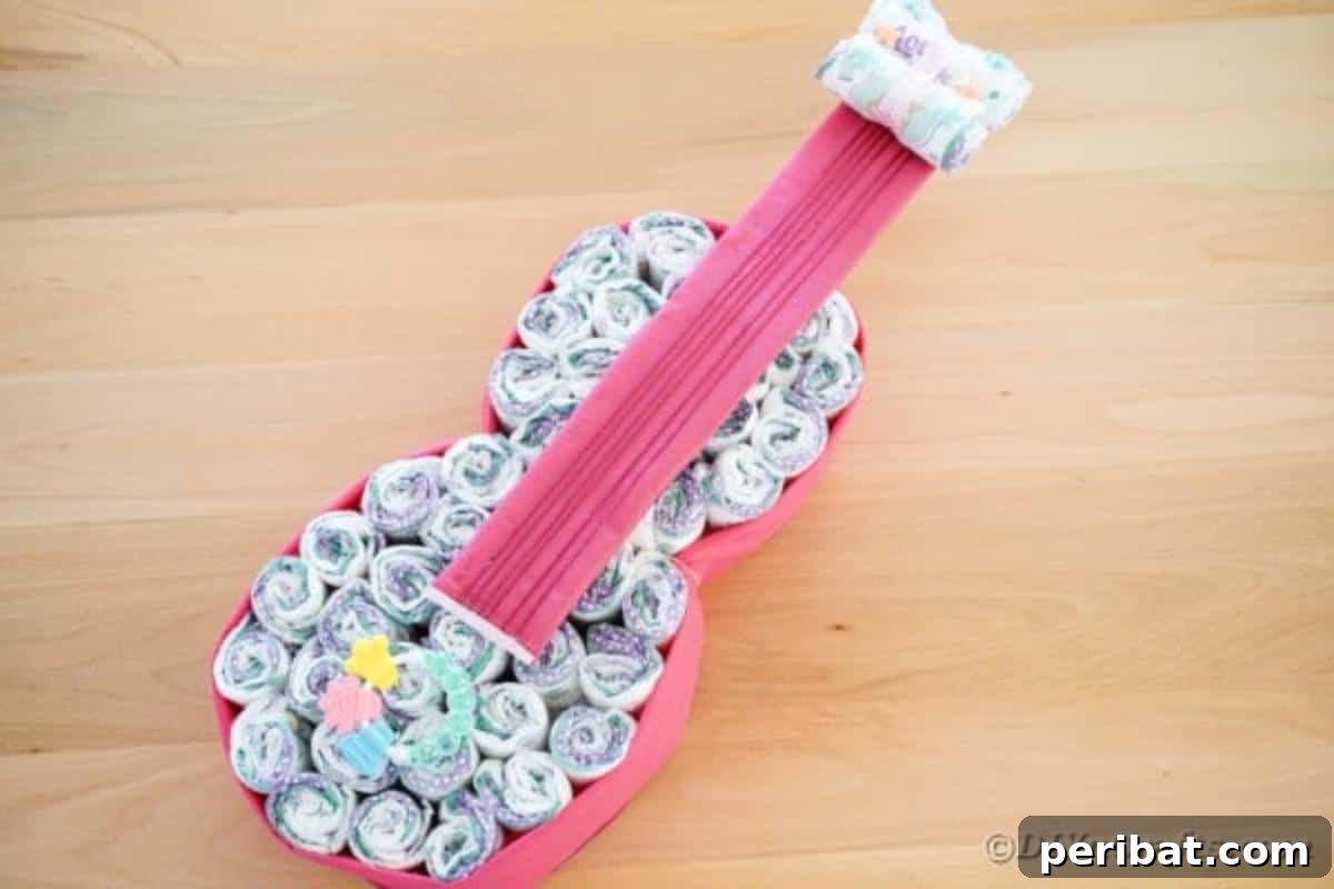 A guitar diaper cake resting on a rustic wooden table, showcasing its intricate details