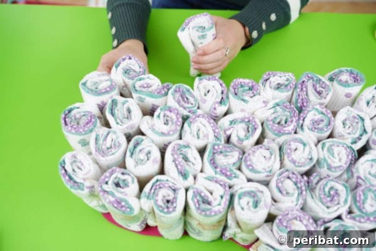 Rolled diapers fully covering the guitar body, with a strip of tissue paper being prepared to wrap around them