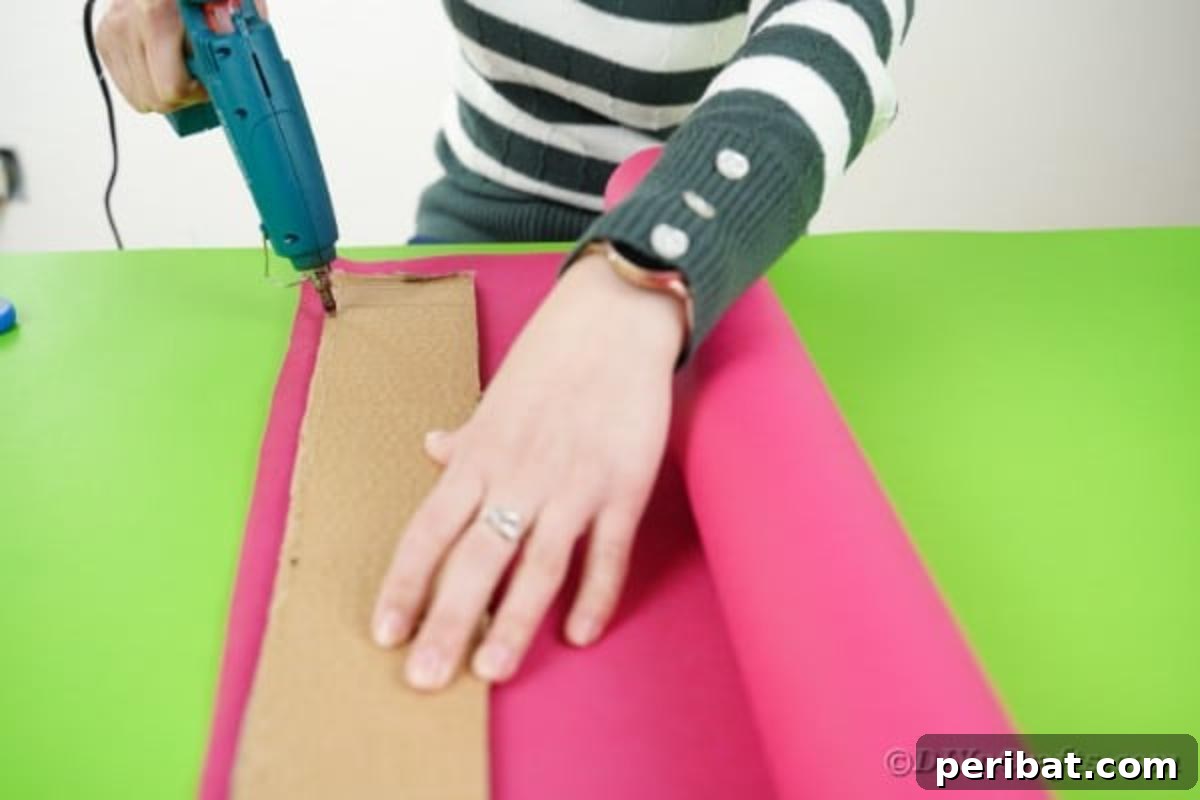 A person gluing tissue paper onto a cardboard strip, showing the neat wrapping process for the guitar neck