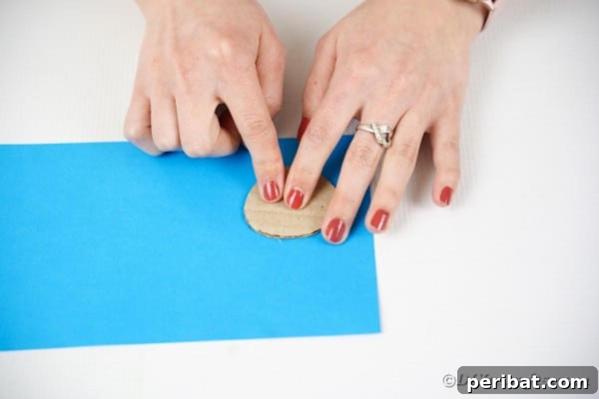 Tracing a cardboard circle onto blue craft paper