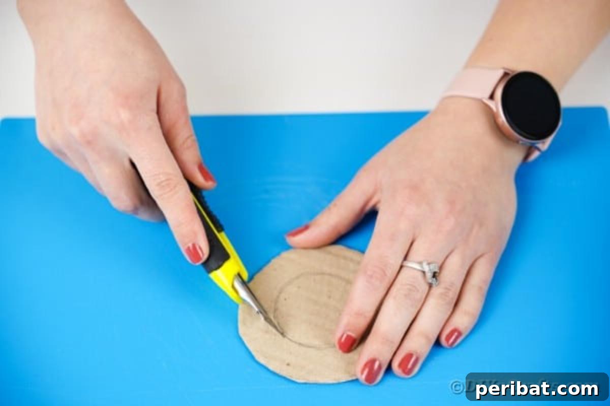 Cutting the center out of a cardboard circle with a craft knife