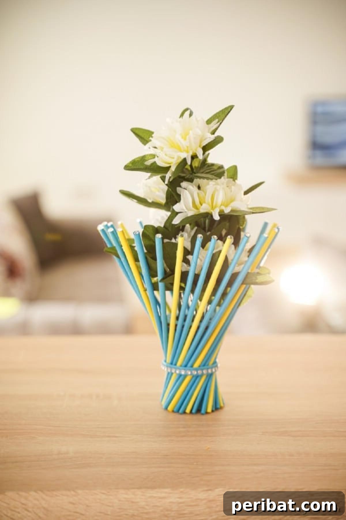Close-up of colorful stick vase on wood table, highlighting texture