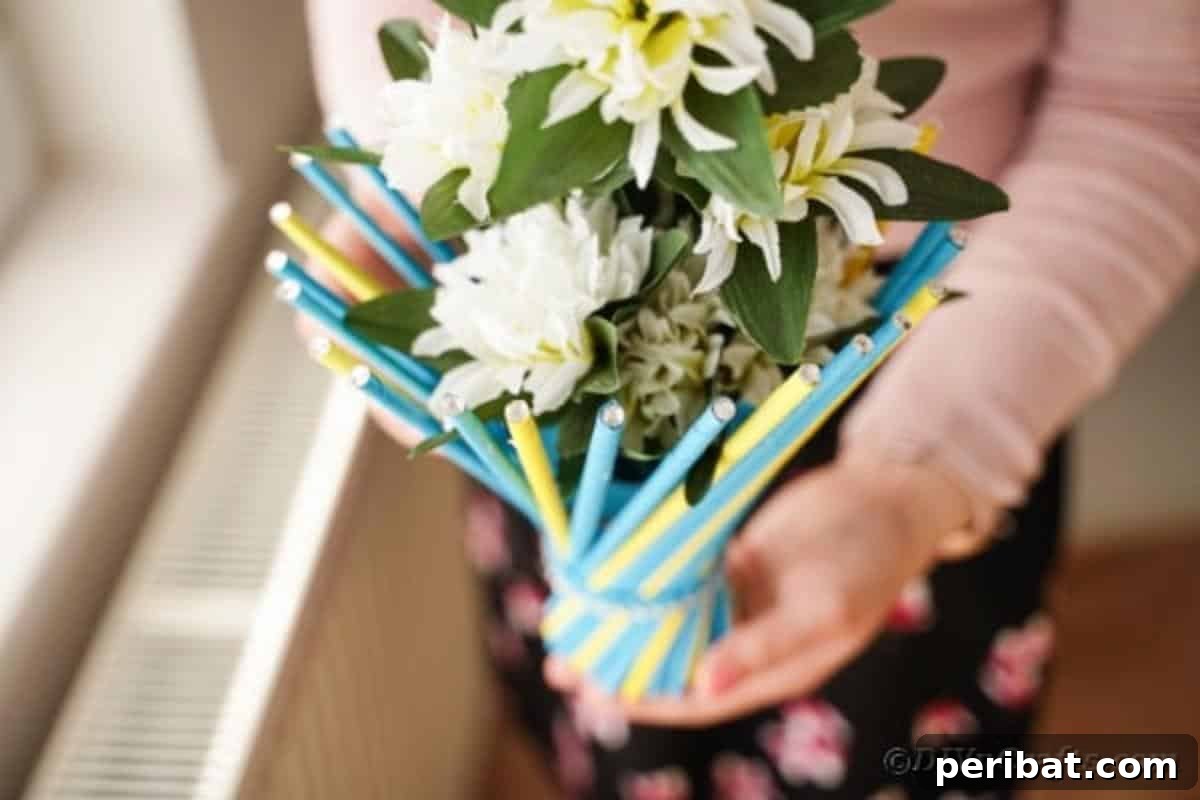 Woman proudly displaying her finished twisted paper straw vase