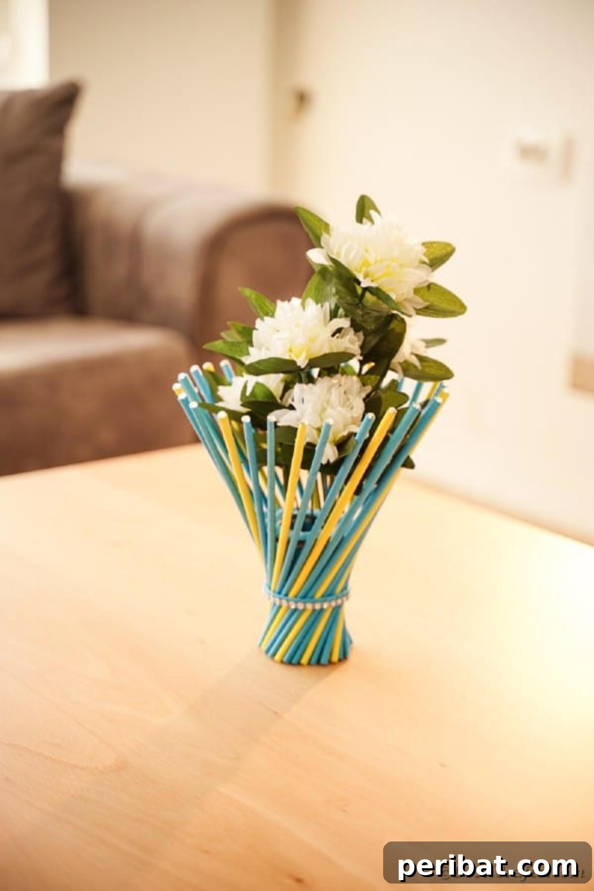 Colorful twisted paper straw vase on a rustic wood table