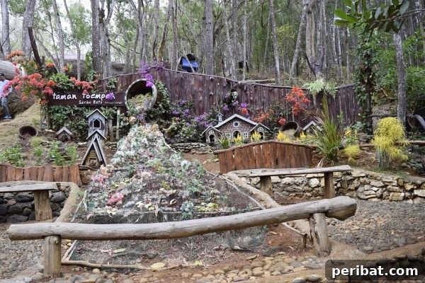 Cascading Flower Pot Art for Stunning Garden Decor 21 An enchanting fairy garden display featuring a half barrel from which flowers and ground cover flow downwards, creating a miniature waterfall effect tailored for a fairy tale setting.