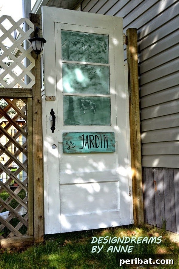 door gate made from a repurposed old door leading into a garden