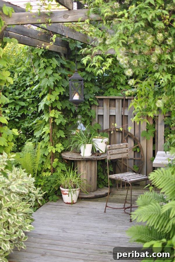 A large wooden spool repurposed as a rustic table, placed in the corner of a wooden gazebo with potted plants and a lantern