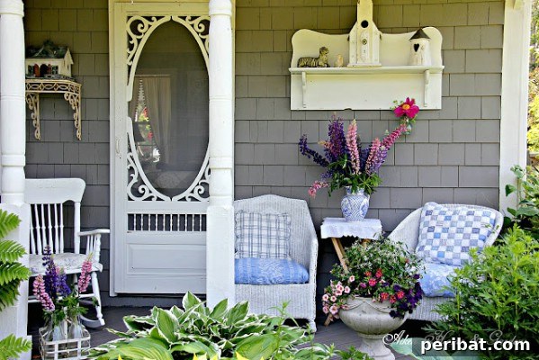 Porch with white wicker, shelves, and a vintage ornate screen door