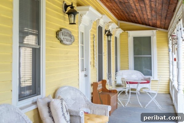 Yellow porch with white wicker furniture and potted plants