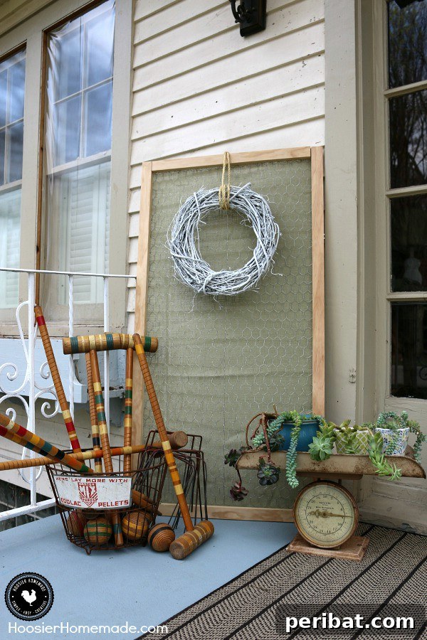 Yard games next to a vintage scale planter on a porch