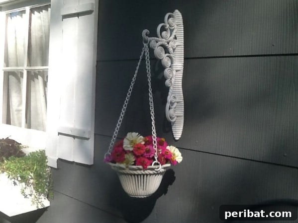 White metal plant hanger with a basket for flowers