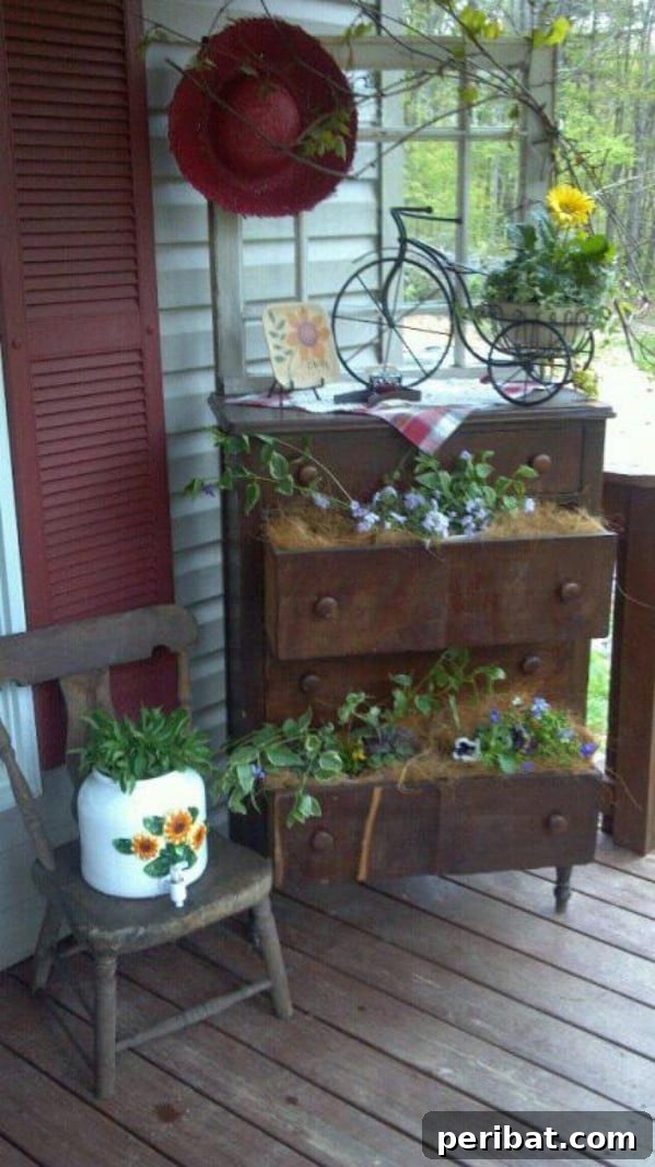 Old dresser repurposed as a multi-level planter on a porch