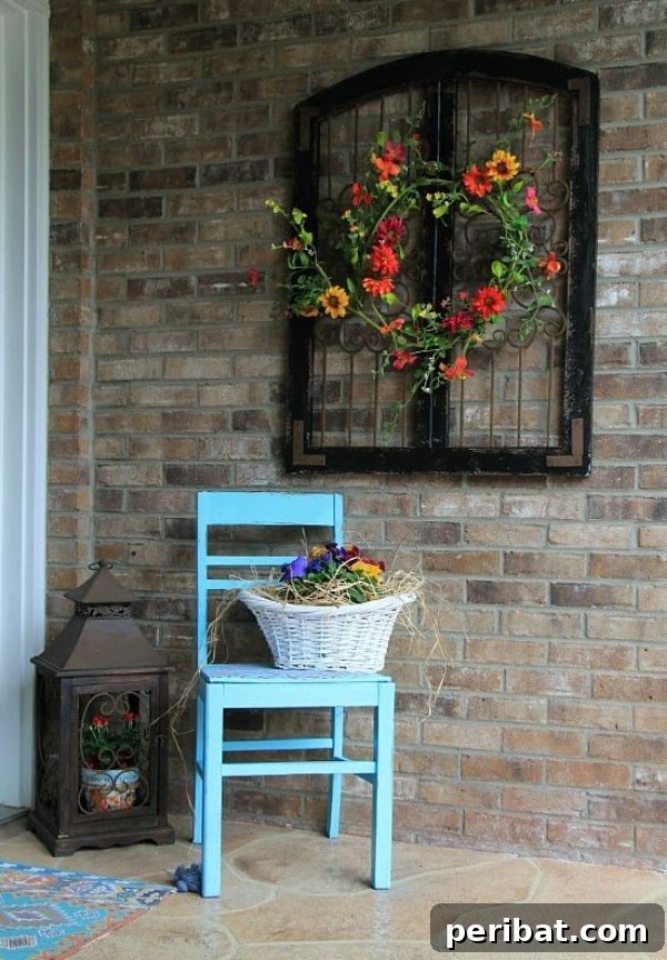 Black window frame holding a floral wreath on a porch