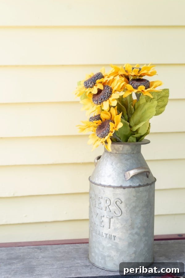 Milk jug filled with sunflowers on a porch step