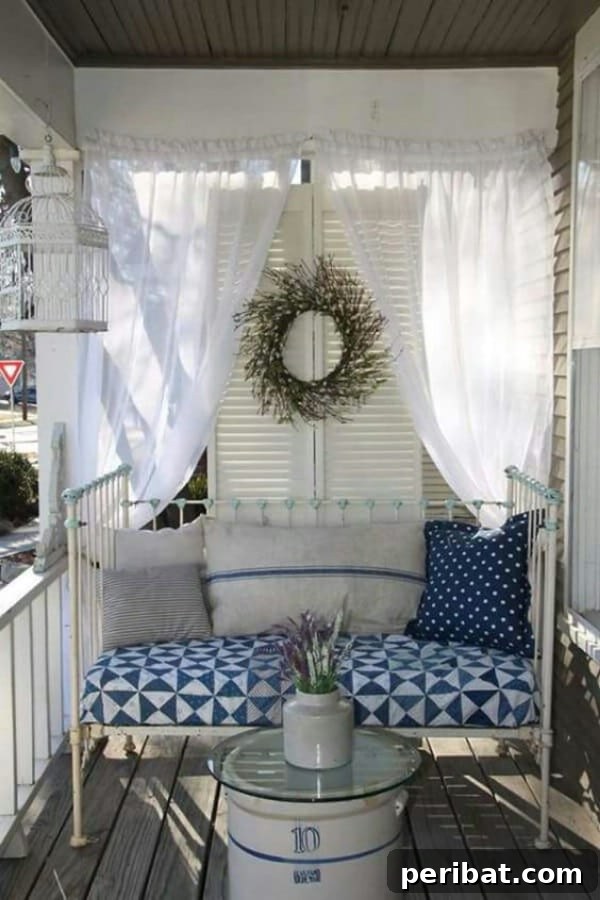 Daybed with white and blue decor on a vintage-styled porch