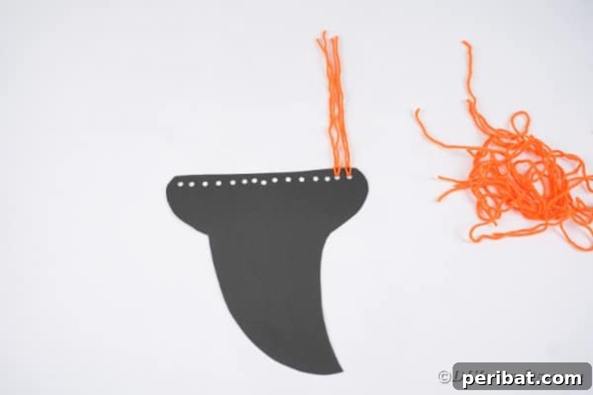 Spooktacular Paper Plate Witch Craft 12 Close-up of orange yarn secured as hair on the witch hat