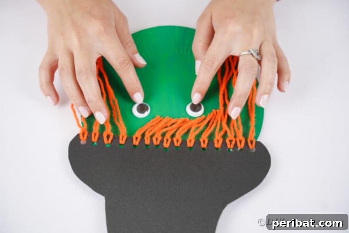 Spooktacular Paper Plate Witch Craft 16 Attaching googly eyes to the paper plate witch face