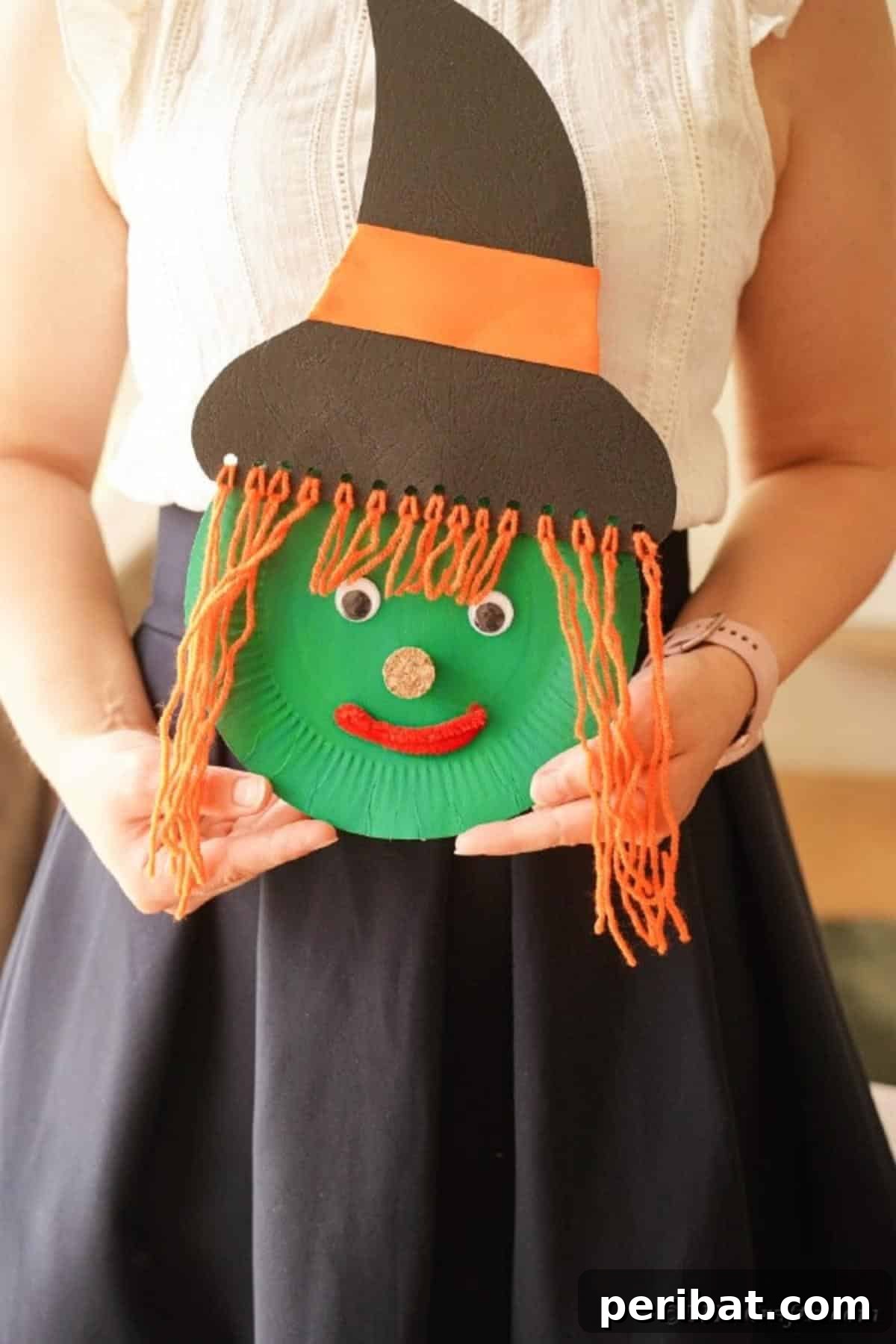 Spooktacular Paper Plate Witch Craft 20 Woman holding the finished paper plate witch craft