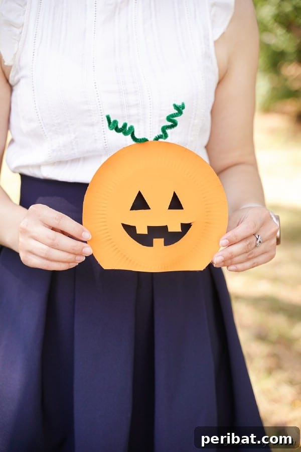 Spooktacular Paper Plate Witch Craft 28 Woman holding paper plate pumpkin
