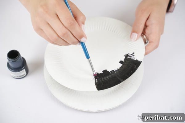 Grinning Gourd Lanterns: A Paper Plate Craft for Kids 19 Painting a paper plate black