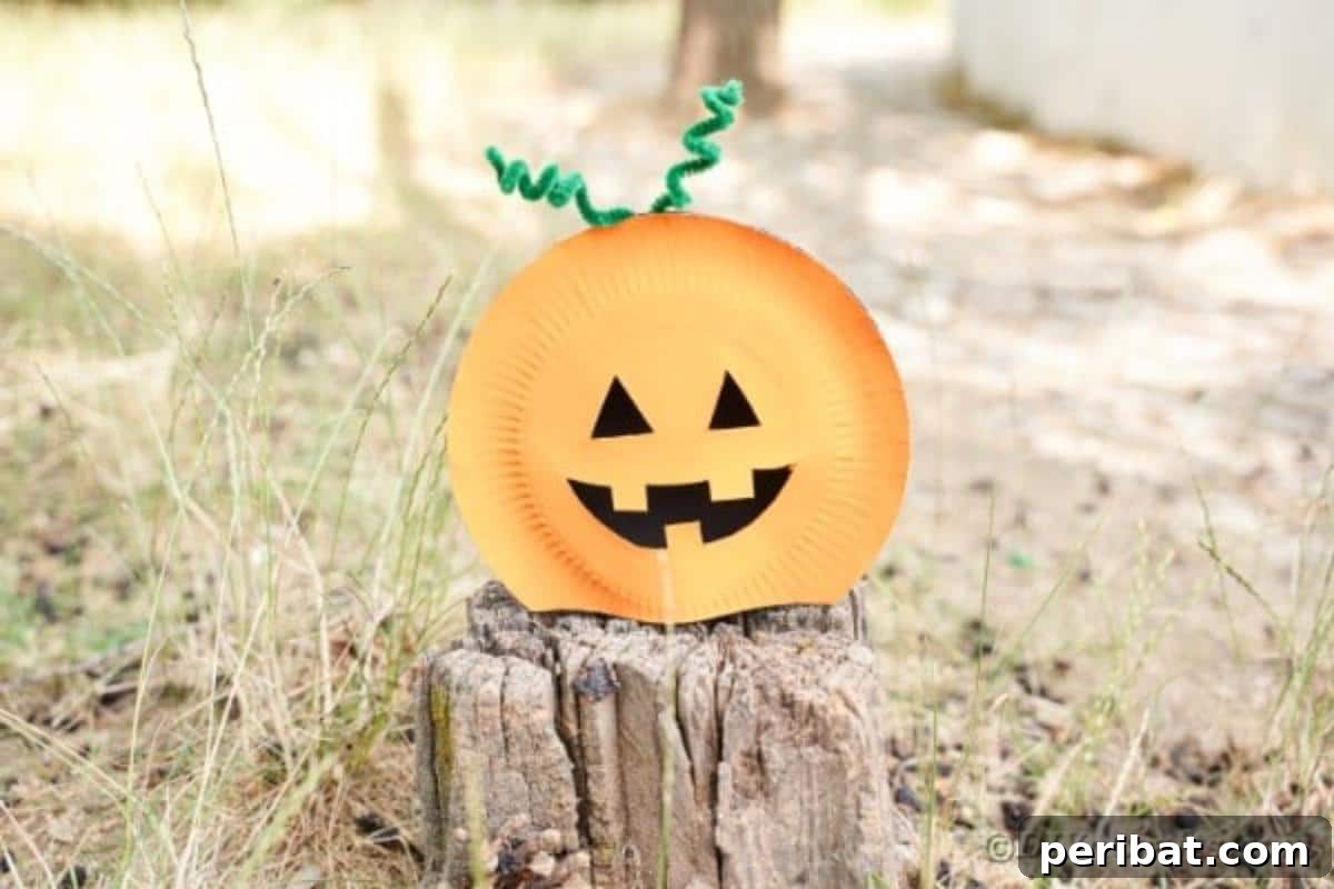 Grinning Gourd Lanterns: A Paper Plate Craft for Kids 4 Pumpkin craft resting on a tree stump outdoors