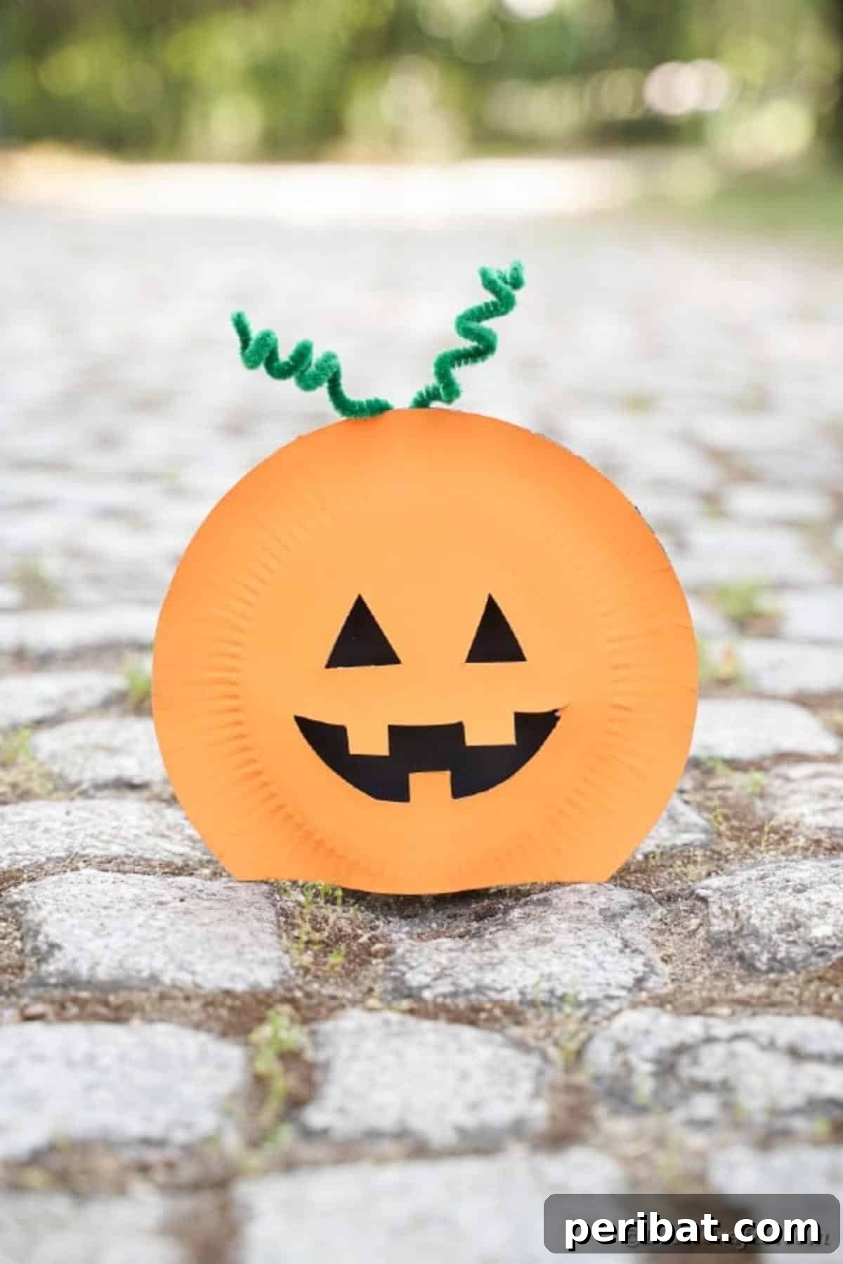 Grinning Gourd Lanterns: A Paper Plate Craft for Kids 6 Paper plate pumpkin lantern displayed on a rock