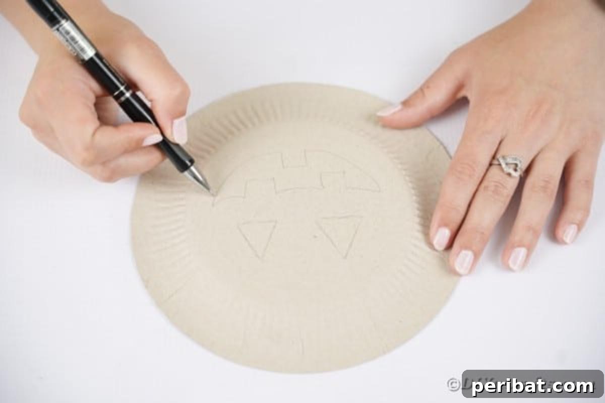 Grinning Gourd Lanterns: A Paper Plate Craft for Kids 9 Tracing a jack-o-lantern face outline on the bottom of a paper plate