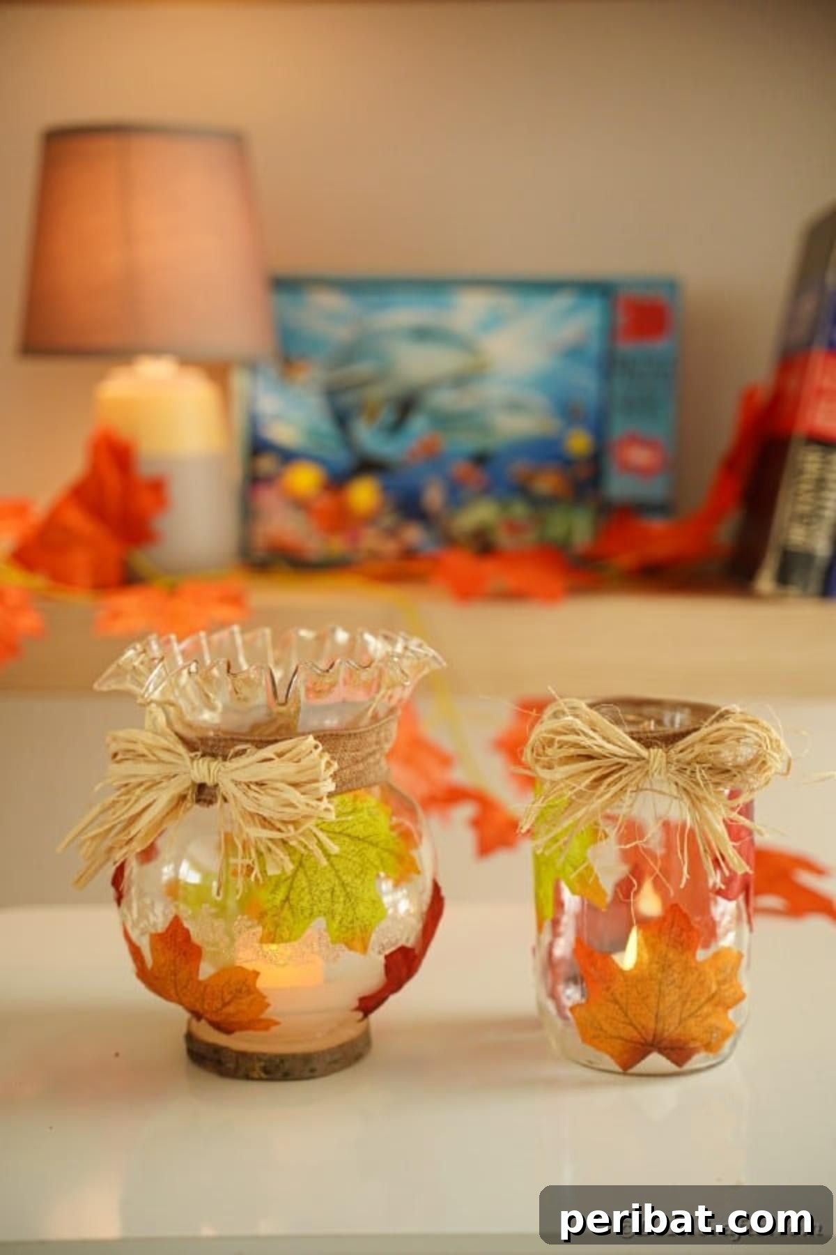 Autumn Leaf Jar Luminaries 19 A single glass fall leaf lantern beautifully displayed on a table indoors, serving as a charming decoration during the day and a glowing accent at night.