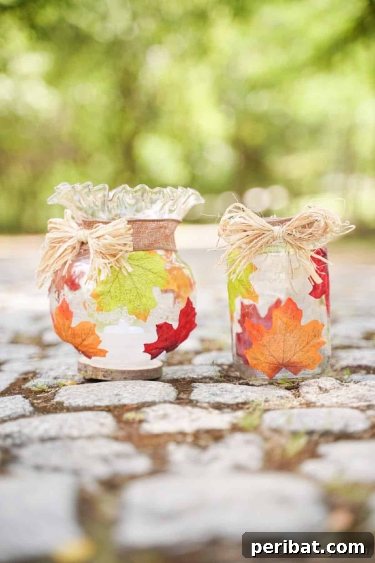 Autumn Leaf Jar Luminaries 20 Two fall leaf decorated jars, illuminated and positioned on natural rocks, suitable for lining a walkway or adding to a garden display.