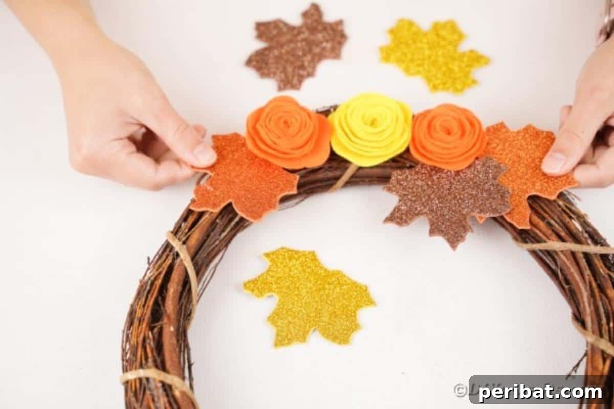 Autumn Grapevine Wreath with Soft Fabric Blooms 17 Adding leaves onto grapevine wreath