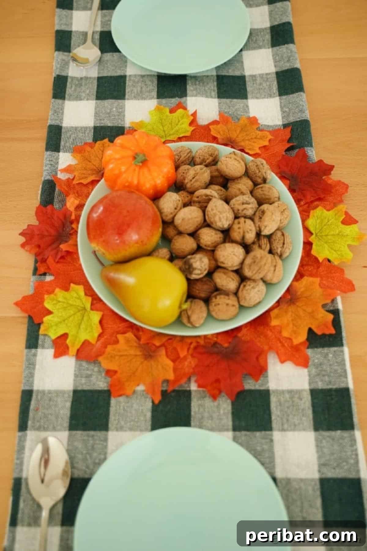 Elegant fall leaf placemat on a checked table runner, showcasing its potential as a centerpiece base