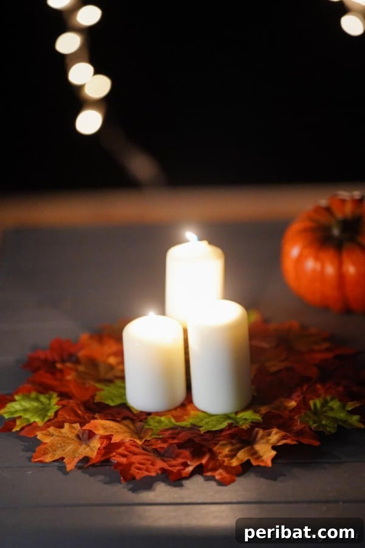 Lit candles casting a warm glow on the DIY fall leaf placemat, creating a romantic ambiance