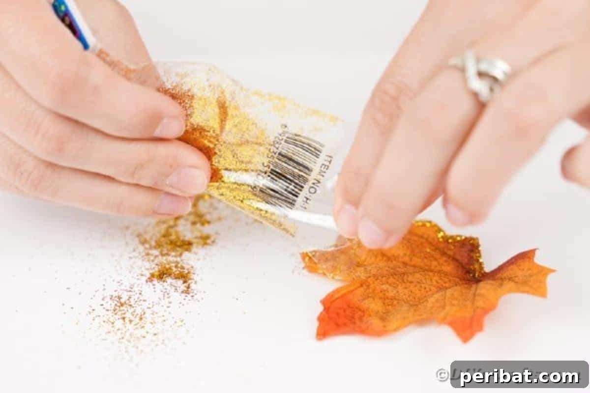 Elegant Autumnal Foliage Wedding Boutonnière 11 An artificial leaf, now sparkling with carefully applied glitter on its edges, being gently shaken to remove excess particles.