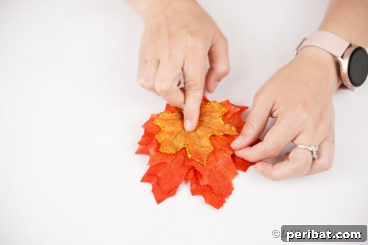 Elegant Autumnal Foliage Wedding Boutonnière 12 Artificial leaves being meticulously stacked and glued together, forming the layered base for the boutonniere.