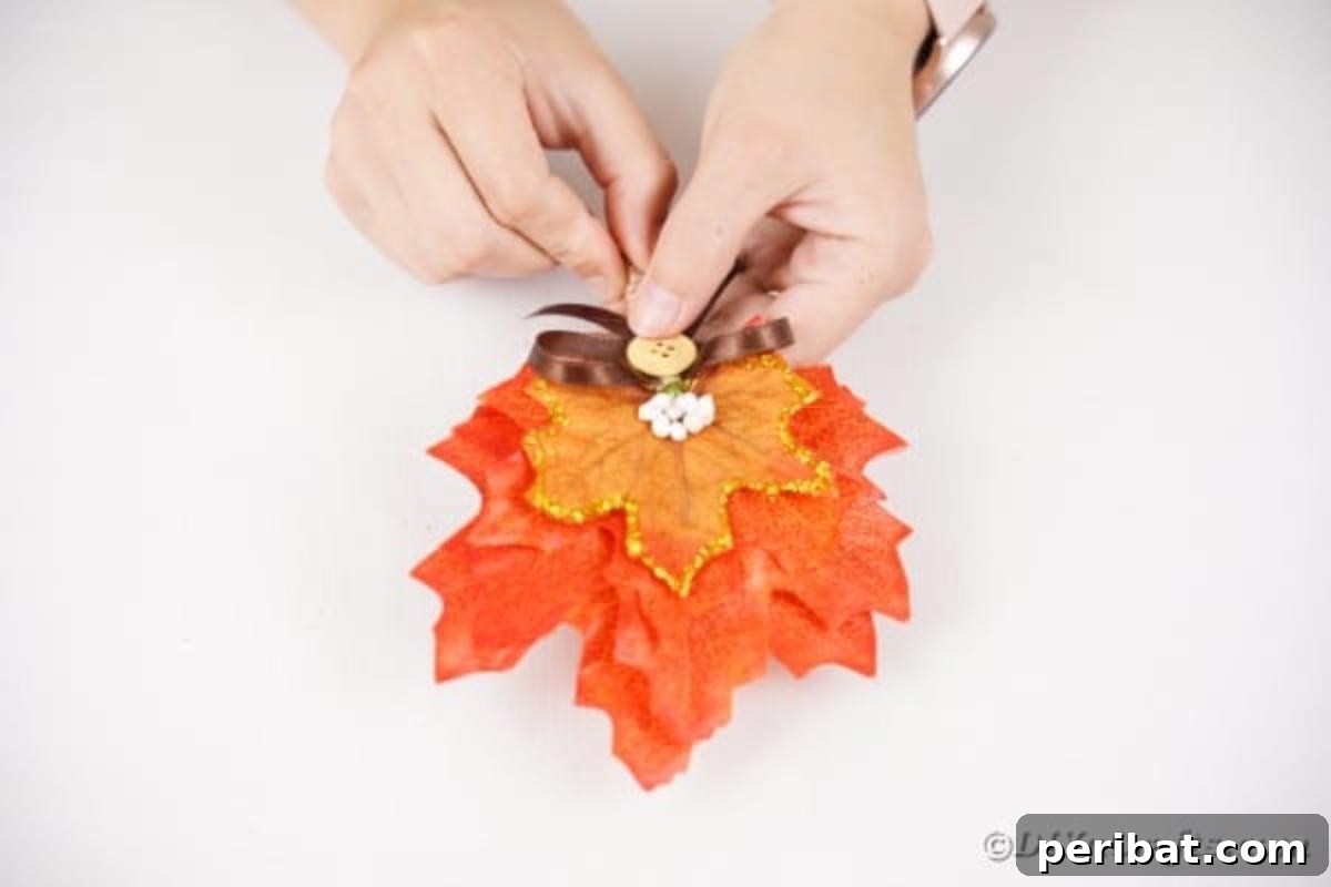 Elegant Autumnal Foliage Wedding Boutonnière 15 A small ribbon bow, adorned with a button in its center, being glued onto the twine-wrapped stem of the boutonniere.