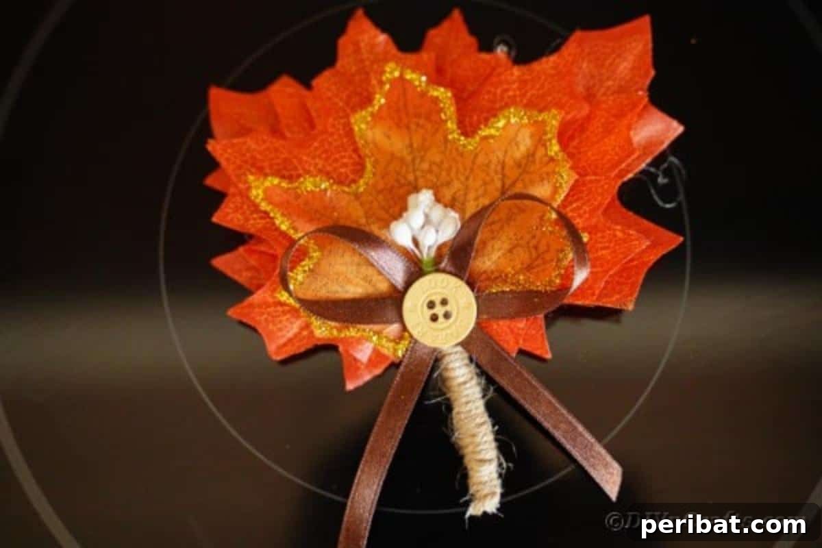 Elegant Autumnal Foliage Wedding Boutonnière 3 A finished fall leaf boutonniere carefully placed on a dark stovetop, highlighting its vibrant autumnal colors and delicate glitter details.