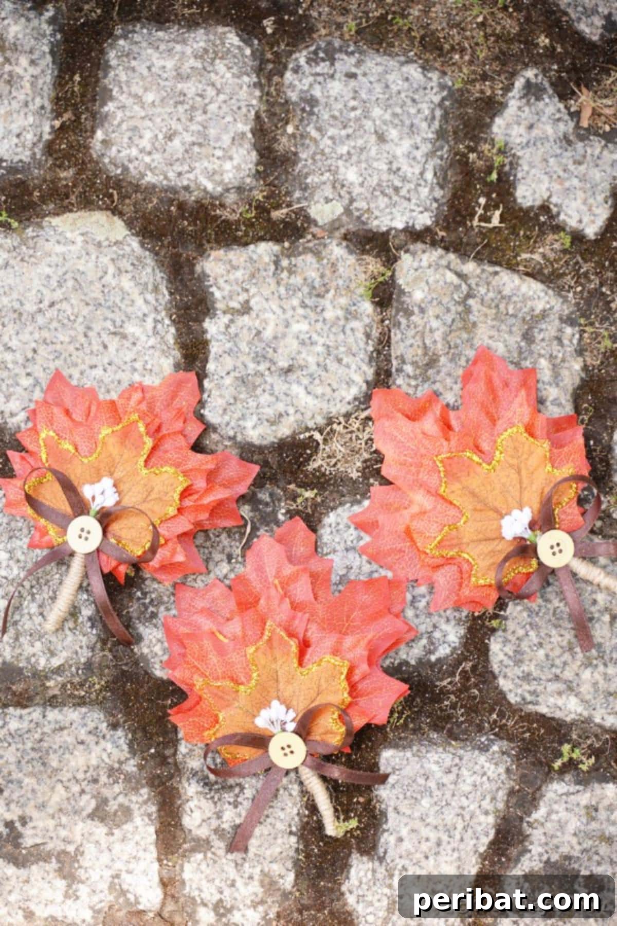 Elegant Autumnal Foliage Wedding Boutonnière 20 A single, elegant fall leaf wedding decoration placed on a textured stone walkway, emphasizing its rustic charm and suitability for outdoor fall themes.