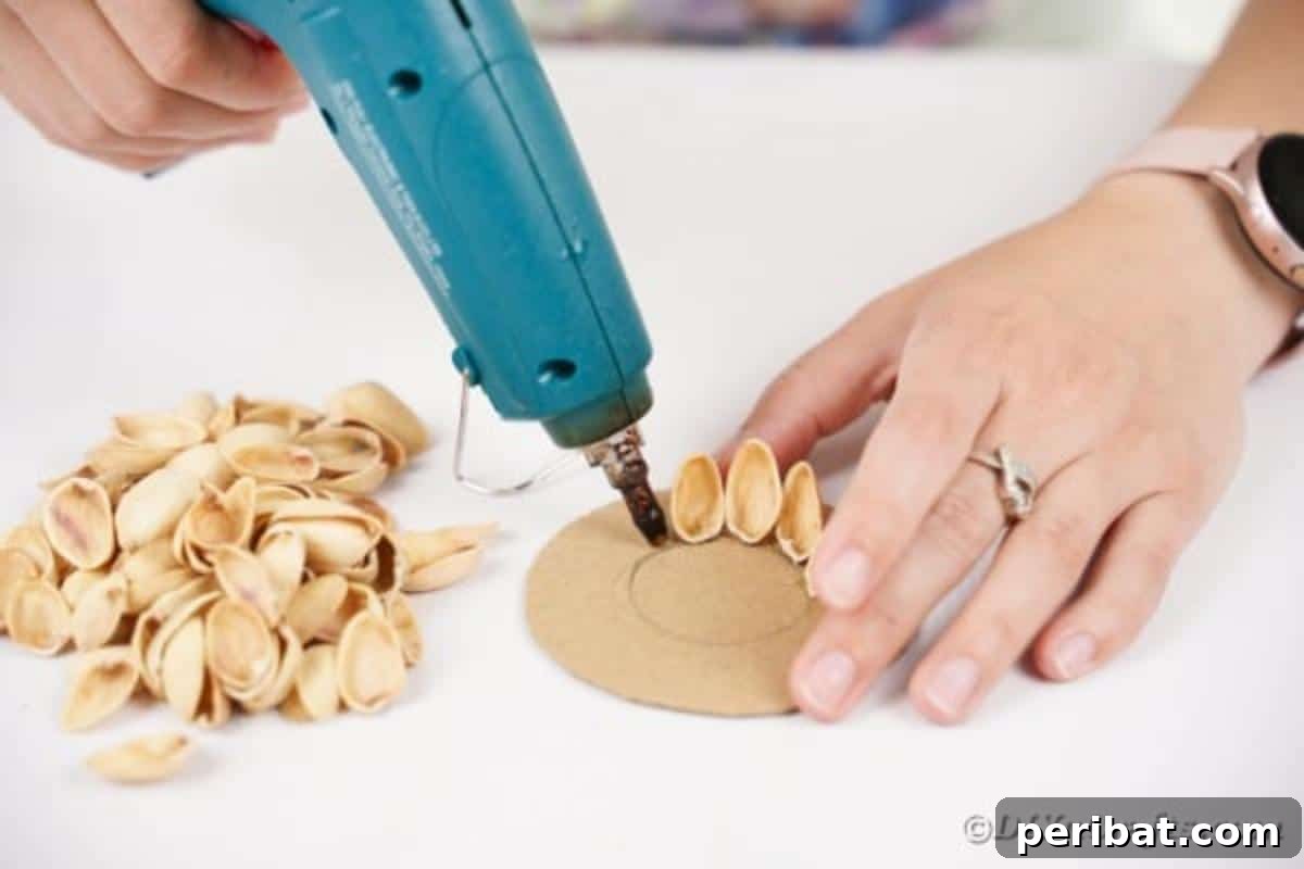 Artisanal Pistachio Shell Candle Holder 12 Pistachio shells being carefully glued around the edge of a cardboard circle