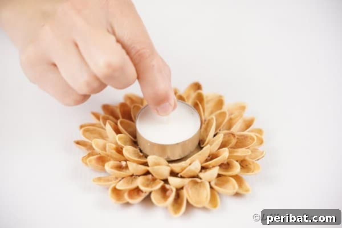 Artisanal Pistachio Shell Candle Holder 15 A woman carefully placing a tealight candle into the finished pistachio shell holder