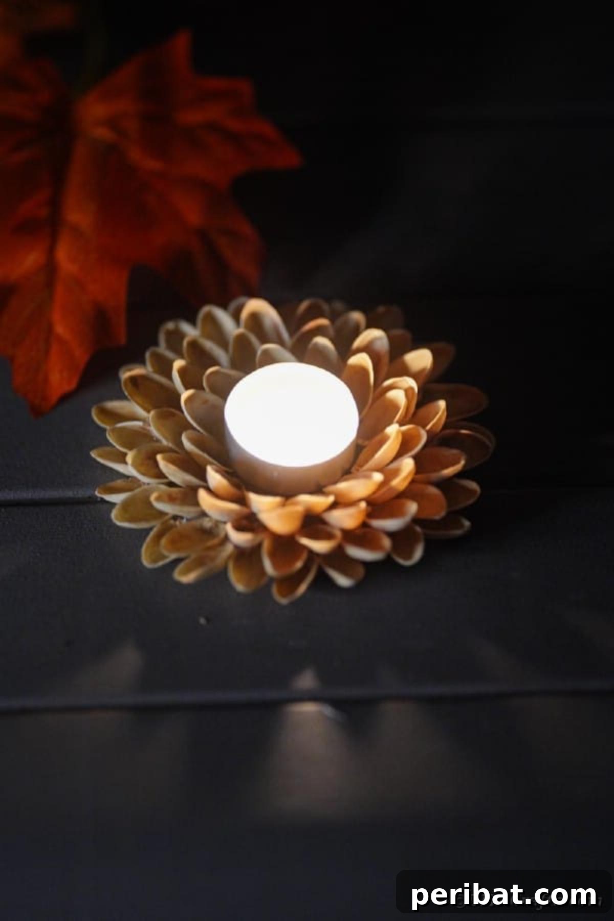Artisanal Pistachio Shell Candle Holder 21 A pistachio shell candle holder beautifully lit, casting a warm and inviting glow
