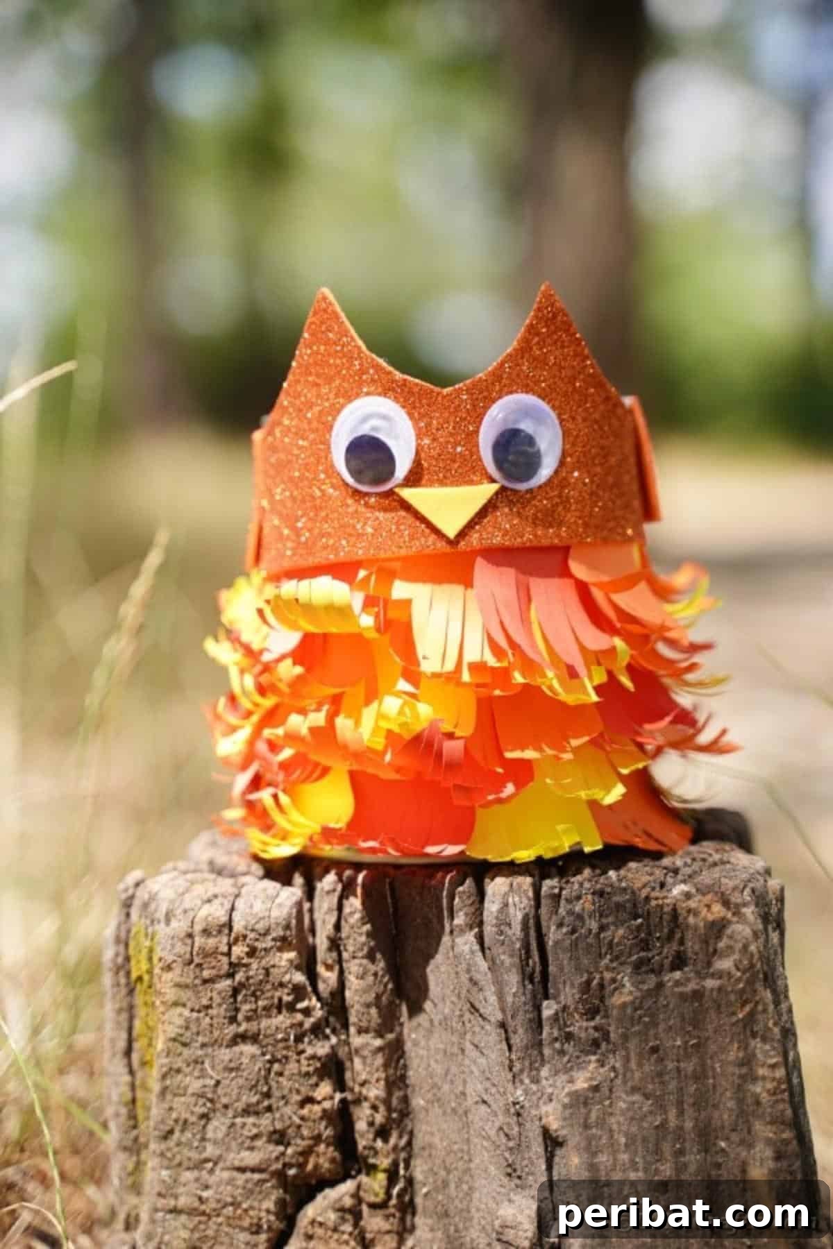 The completed upcycled tin can owl, filled with pencils and displayed on a tree stump, ready for use.