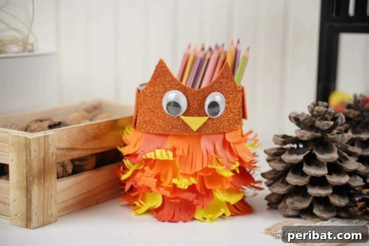 Close-up of a finished tin can owl craft, positioned next to a rustic wooden box, highlighting its intricate paper feather details.