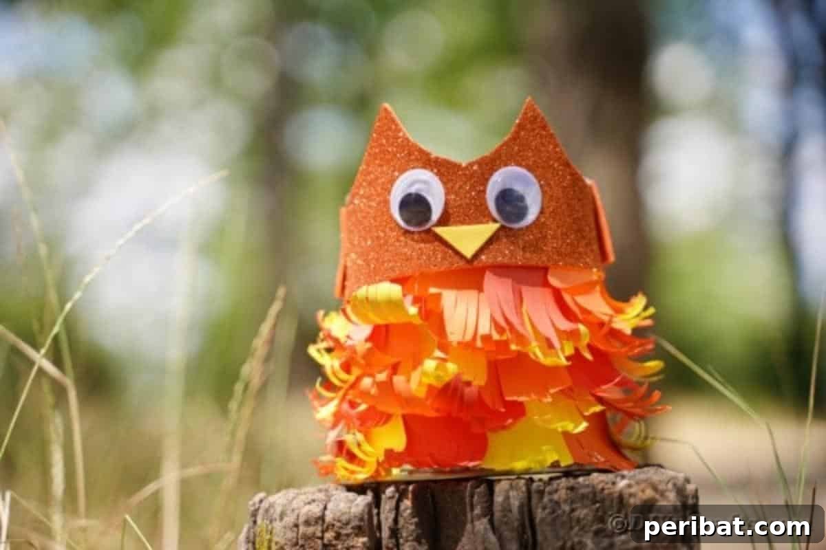 A creatively adorned tin can owl with paper feathers on a tree stump, showing the full body details.