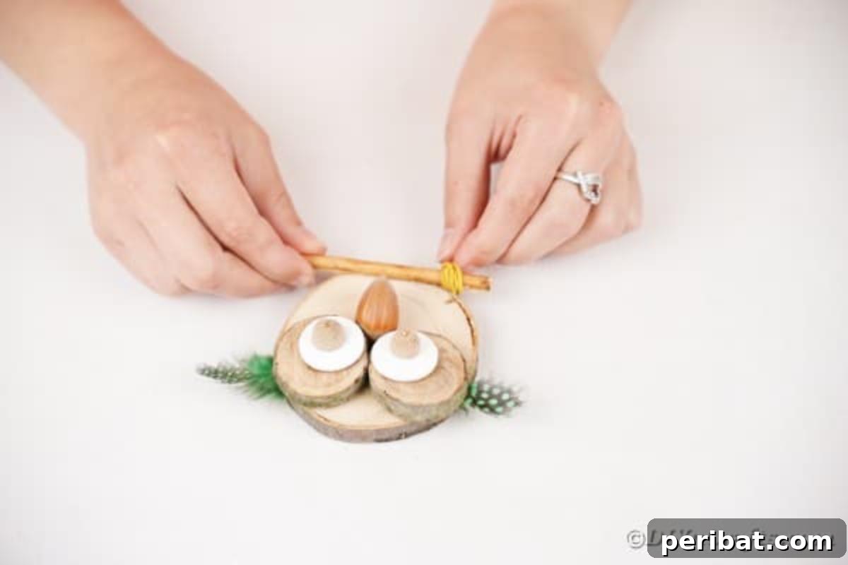 Whimsical Wooden Owls from Recycled Scraps Video Guide 13 Instructions for creating the owl's twig arms: rubber bands are being wrapped multiple times around each end of a small stick, adding texture and securing the ends.