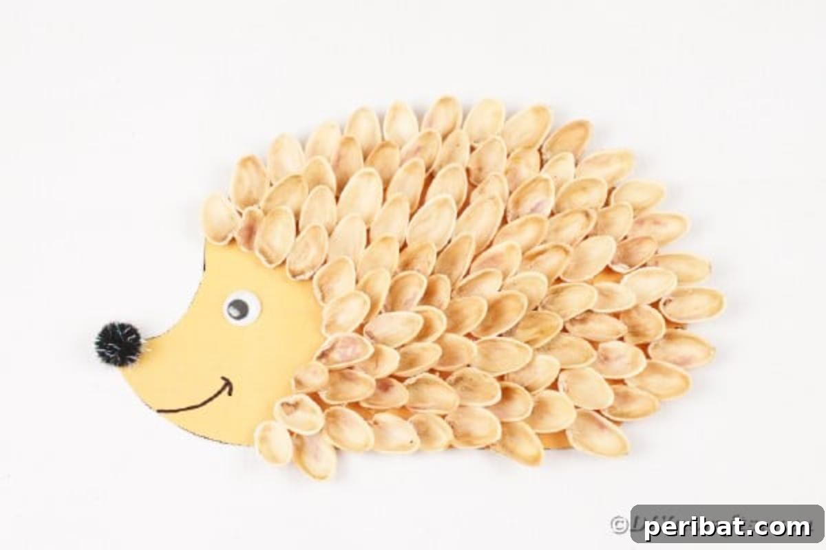 A finished pistachio shell hedgehog craft displayed on a clean white table, showcasing its complete and charming appearance.